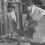 Two members of the Fire Prevention Squad inspecting remains of dormitory fire at Heart Mountain incarceration camp
