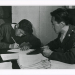 Young Nisei man completing questionnaire before enlisting