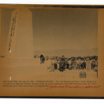 Crowd stands near a memorial monument at Manzanar