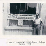 James Omura standing before Voluntary Headquarters, Pacific Coast Evacuee Placement Bureau